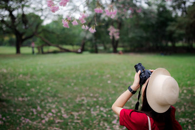 Woman photographing on field