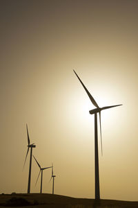 Windmills for electric power production at sunrise.