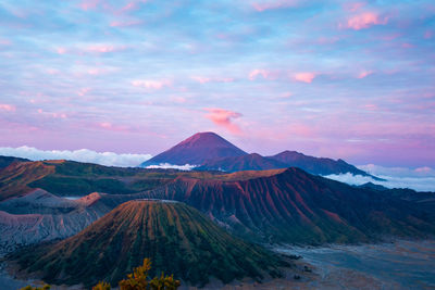 Scenic view of mountains against cloudy sky during sunset