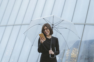 Young woman wearing mask standing in rain