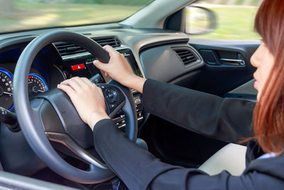 Midsection of woman sitting in car