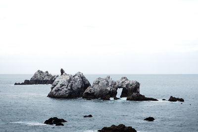 Rocks in sea against sky