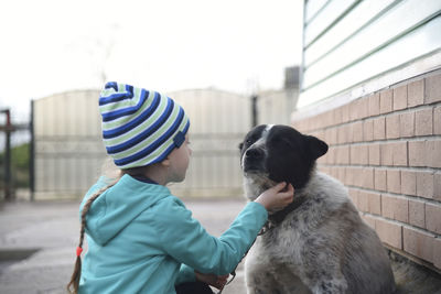 Rear view of person with dog during winter