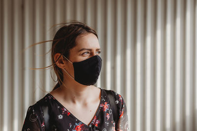 Young woman wearing mask looking away