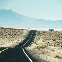 Road by mountains against clear sky