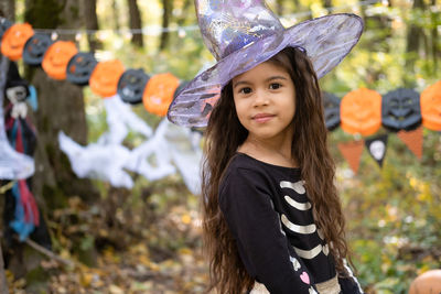 Halloween. portrait of cute arab girl in halloween costume and witch hat outdoor