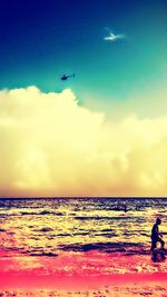 Silhouette of people on beach at sunset