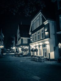 Street amidst buildings in city at night