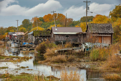 Buildings by river against sky