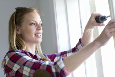 Young woman repairing window, stockholm, sweden