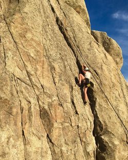 Low angle view of man rock climbing