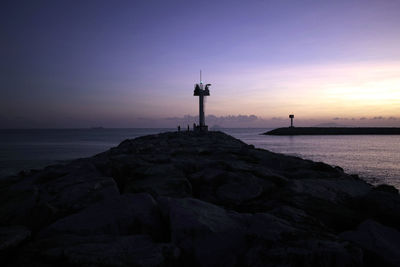 Silhouette of lighthouse at seaside