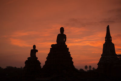 Low angle view of statues and temple against sky