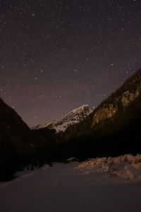 Scenic view of snowcapped mountains against sky at night