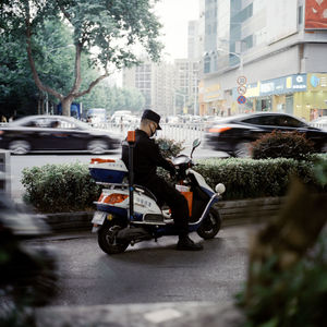 Man riding motorcycle on street in city