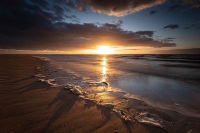 Scenic view of beach against sky during sunset