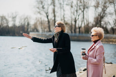 Mother and daughter spending time together. feeding birds. enjoying springtime.