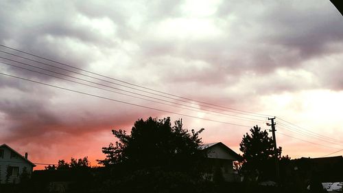 Electricity pylon against cloudy sky