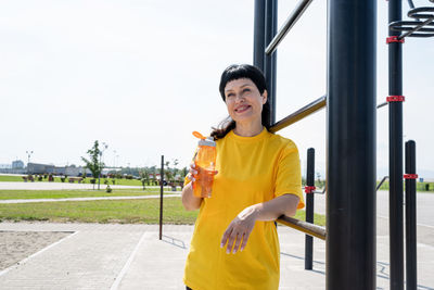 Portrait of a smiling young man drinking water