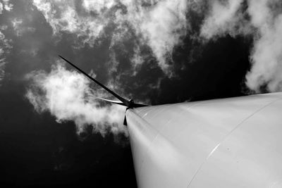 Directly below shot of wind turbine against cloudy sky