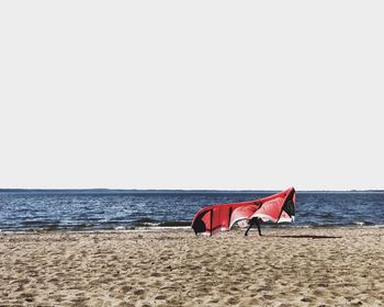 Deck chairs on beach against clear sky