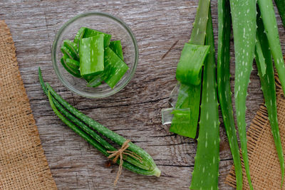 High angle view of aloe vera with slices at wooden table