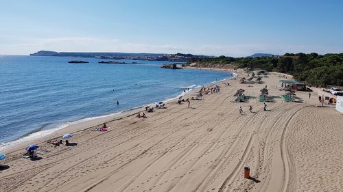 People at beach against sky