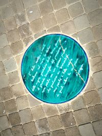 High angle view of manhole on walkway