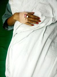 Midsection of female patient lying on bed at hospital