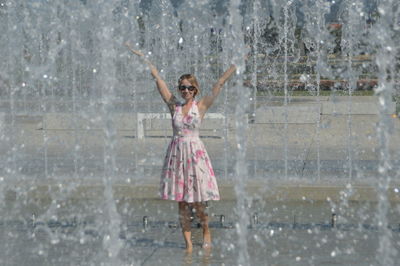 Woman seen through water spraying at fountain