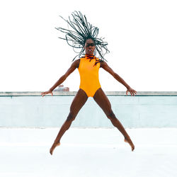 Full length of woman standing by swimming pool against sky