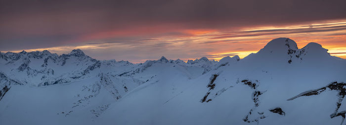 Scenic view of snowcapped mountains against sky during sunset