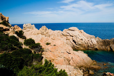 Rock formations by sea against sky