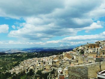 High angle shot of townscape against cloudy sky