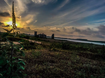 Scenic view of grassy field against cloudy sky