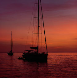 Sailboat sailing on sea against sky during sunset