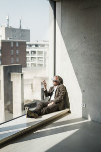 Senior businessman with vr glasses looking through window at office