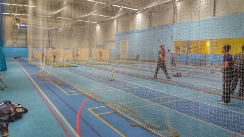 Cricketers practicing indoors