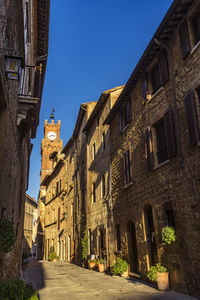 Street amidst old buildings against clear blue sky