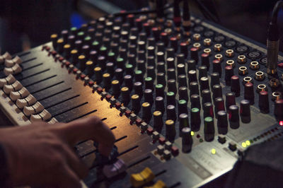 Cropped hand of man with sound recording equipment in studio