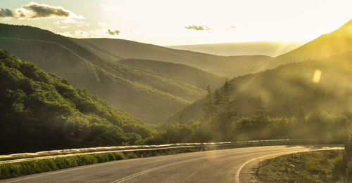 Road by mountains against sky