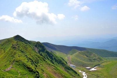 Scenic view of mountains against cloudy sky