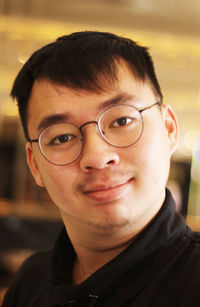 Close-up portrait of smiling young man in eyeglasses