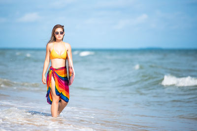 Portrait of young woman walking on beach