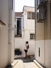 Full length of man looking up while standing in front of house