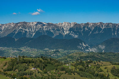 Scenic view of landscape and mountains against blue sky