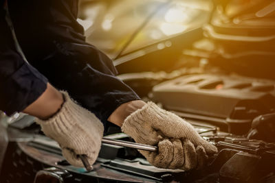 Midsection of mechanic repairing car