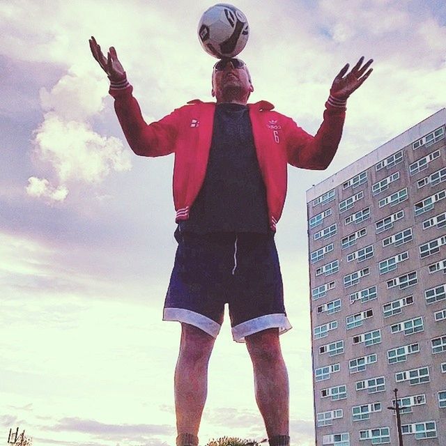 sky, lifestyles, leisure activity, standing, low angle view, cloud - sky, holding, casual clothing, arms raised, three quarter length, men, full length, outdoors, day, built structure, building exterior, person, cloud