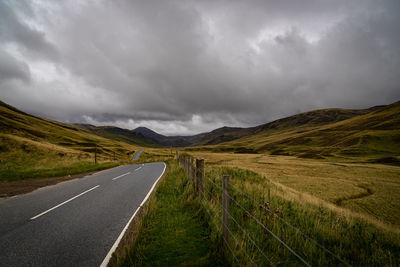 Scenic view of road by land against sky