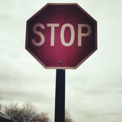 Low angle view of road sign against sky